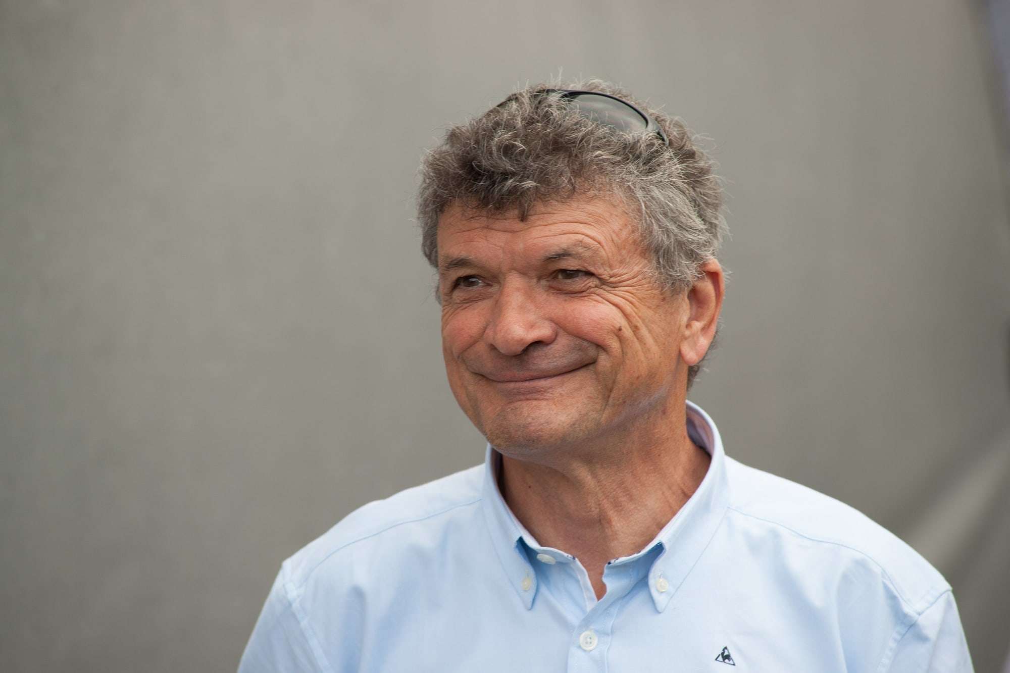 Portrait de Bernard Thévenet en chemise bleu clair, souriant