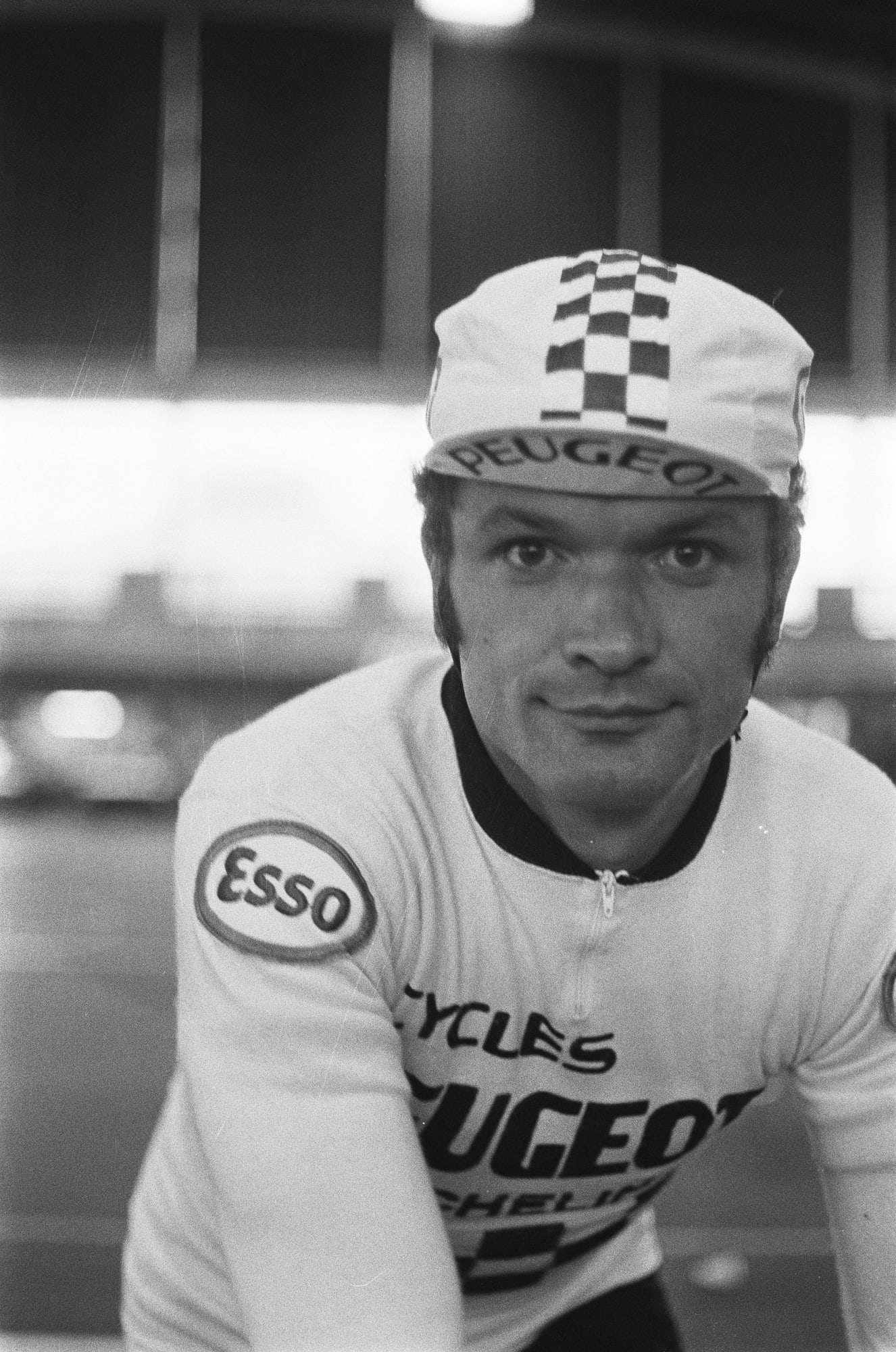 Bernard Thévenet en maillot Peugeot et casquette à damier, regard vers l'objectif